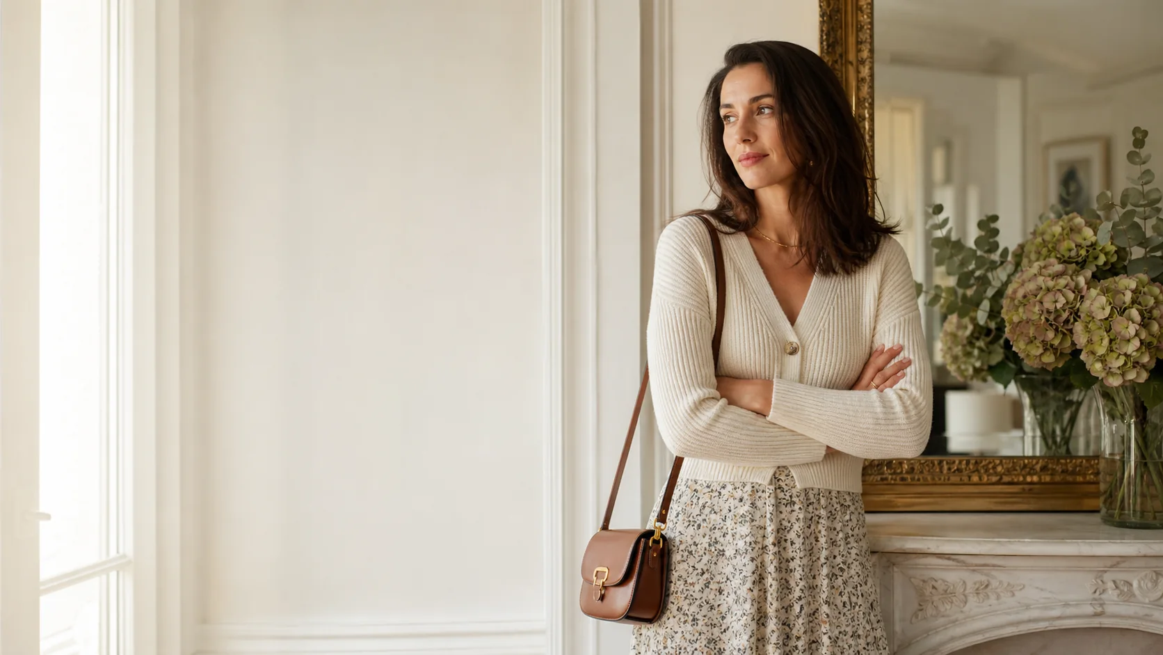 Woman wearing a cream cardigan and patterned skirt in a bright classic interior